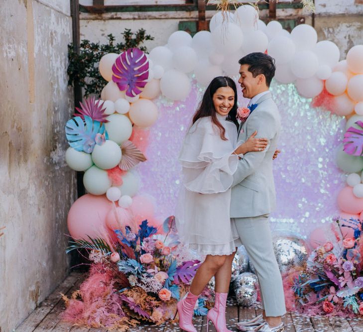 Bride and groom standing in front of a balloon installation 