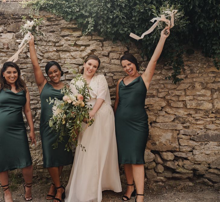 Bride and bridesmaids in green satin dresses at micro wedding 