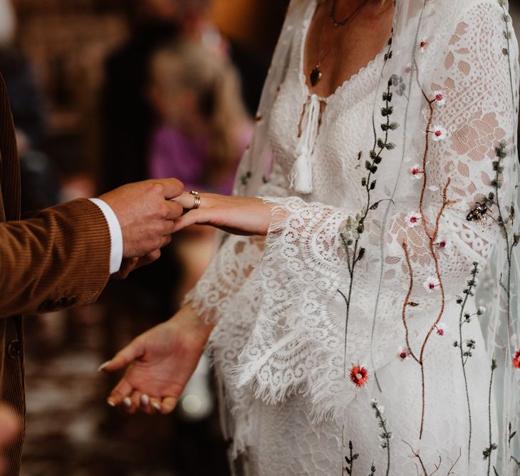 Groom putting on his brides wedding ring 