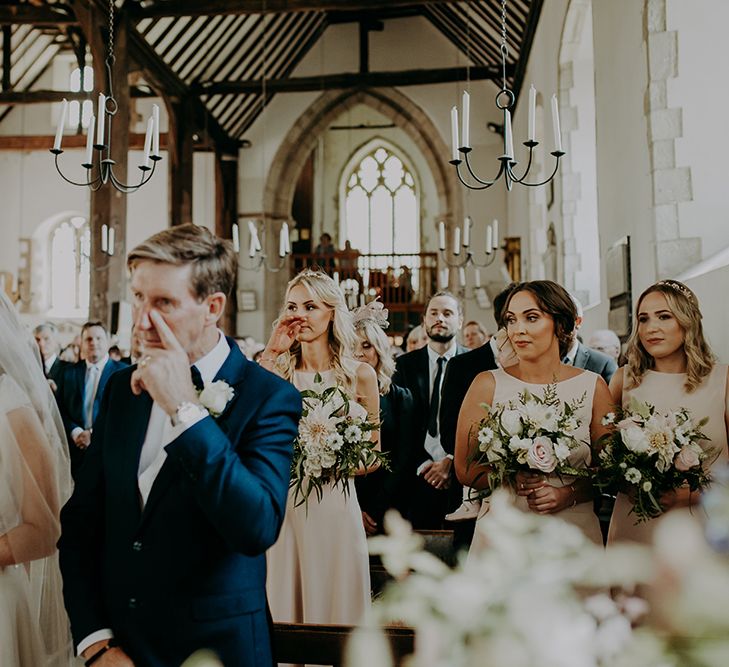 Emotional father of the bride and bridesmaid at church wedding ceremony 