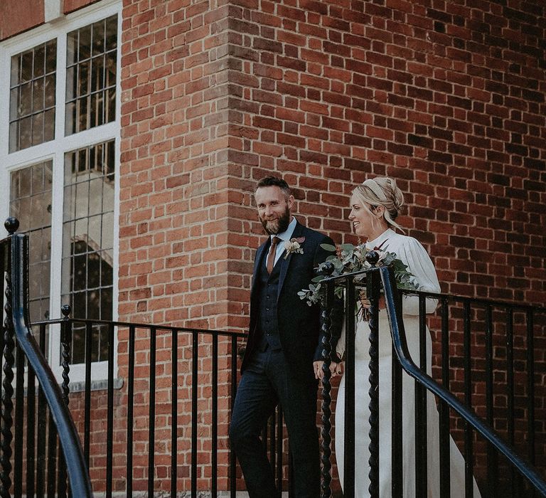 Bride and groom walking down the steps 