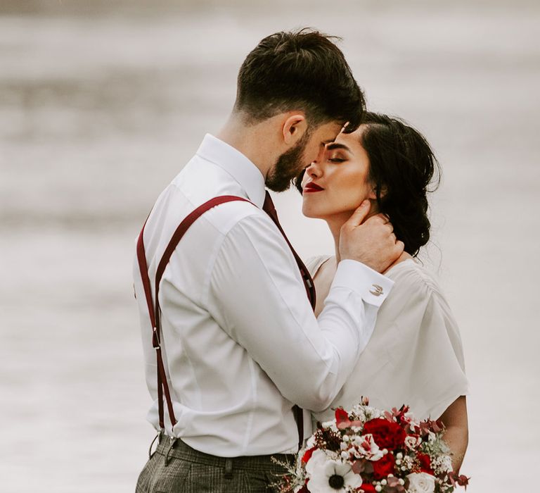 Bride and Groom look into each others eyes by lake