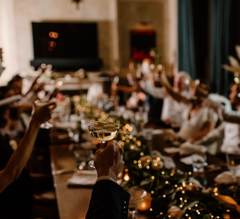 Intimate wedding celebrations wedding guests toasting with champagne coupes 