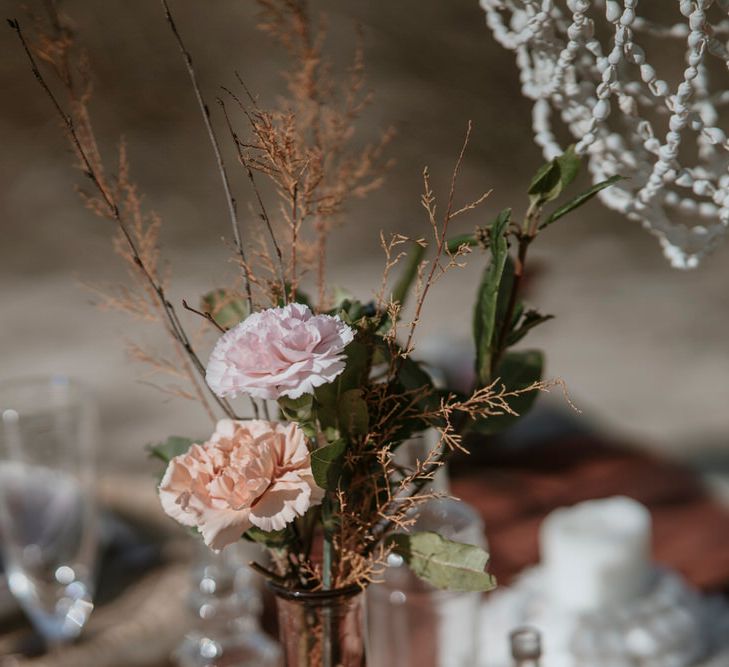 Simple pink flowers in a vase at the wedding table