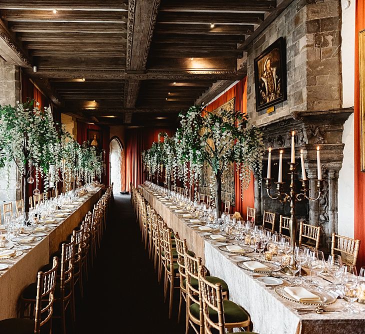 Luxe wedding reception at Leeds castle with banquet tables, silver candelabras and miniature tree centrepieces