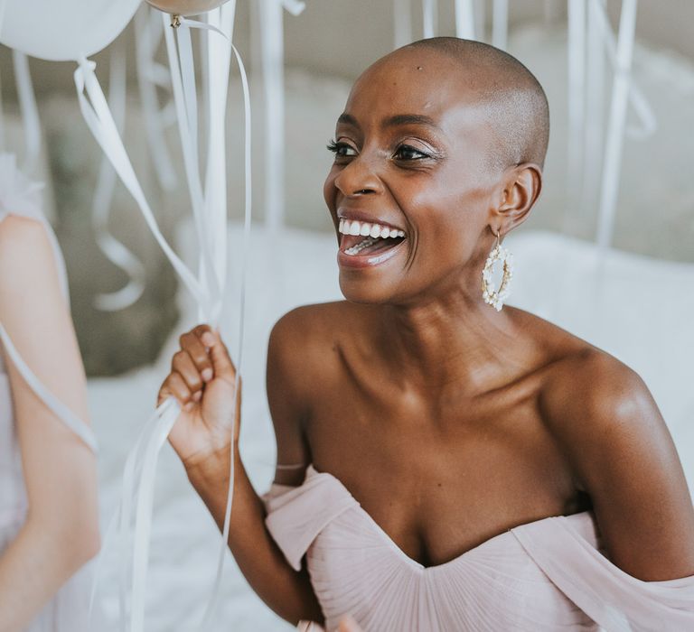 Black bride in chiffon off the shoulder TH&TH bridesmaid dress laughing 