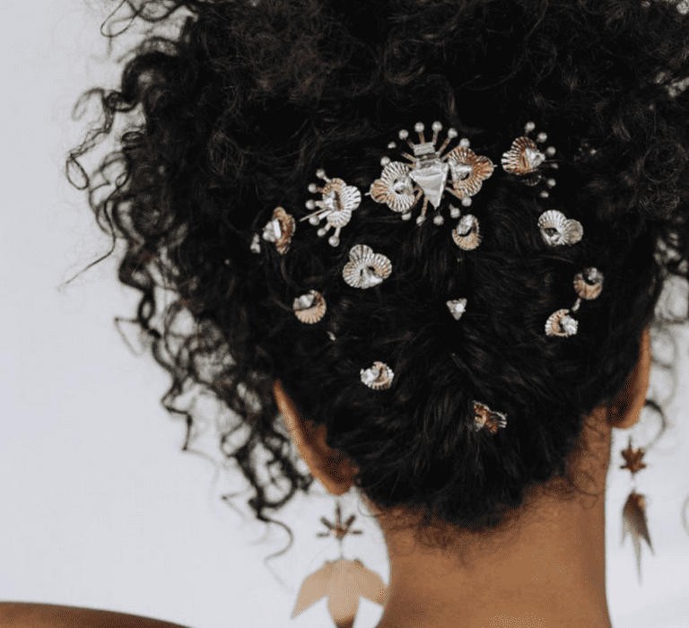 Hairstyles for Black brides. An updo for curly afro hair with jewelled pins