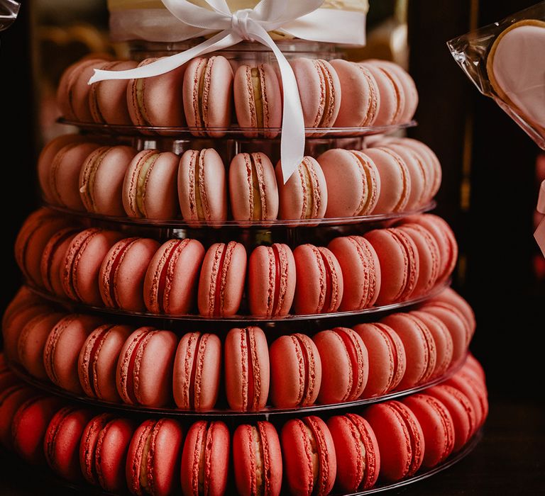 Ombre pink macaron tower under buttercream iced wedding cake