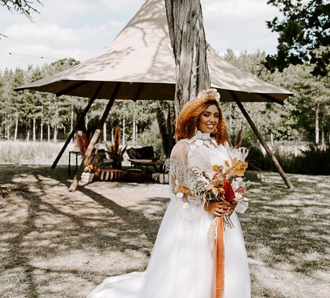 Bride walks down the aisle in boho wedding gown complete with dried floral bouquet