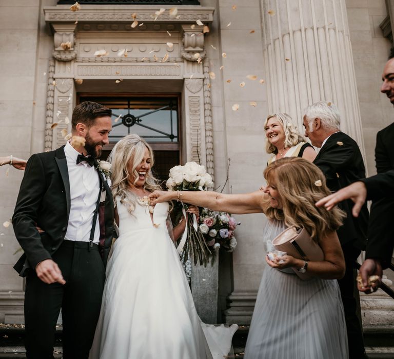 Bride & groom kiss on the steps of Marylebone Town Hall