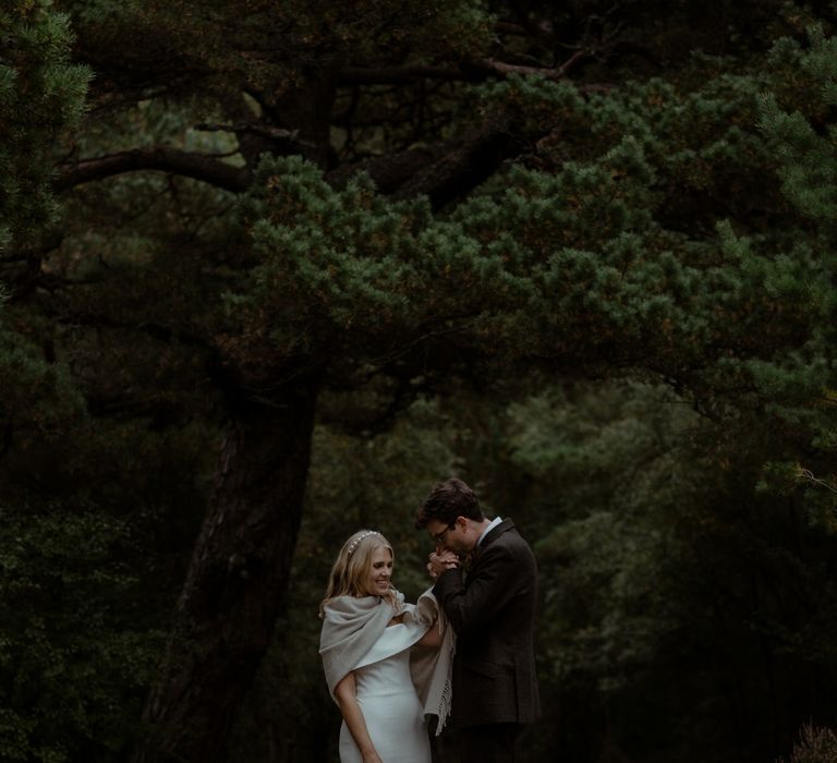 Bride & groom stand together on the day of their wedding outdoors