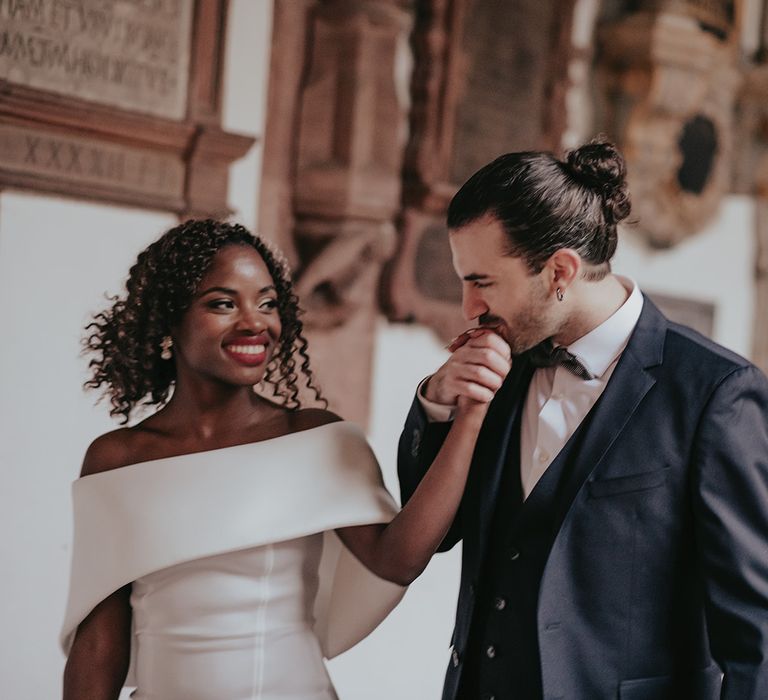 Groom kisses brides hand whilst they walk along together