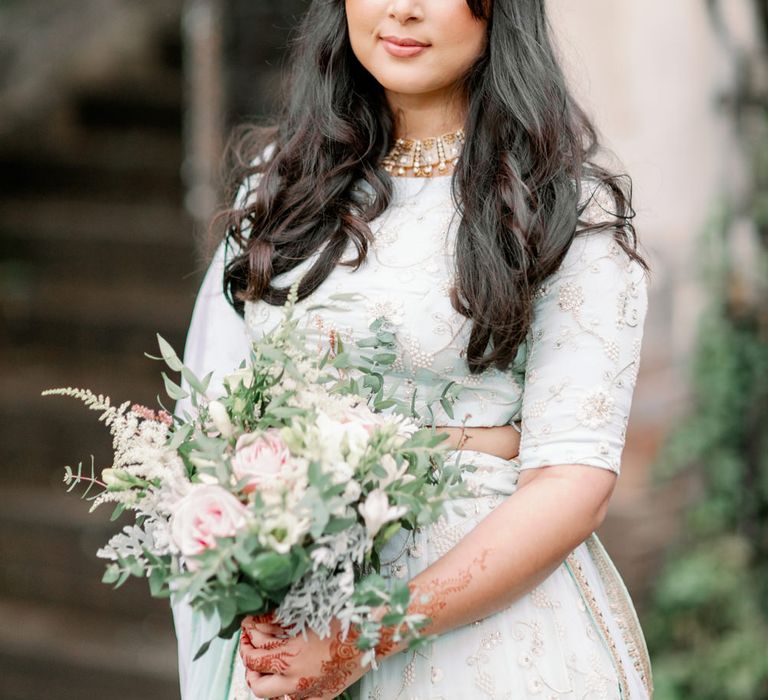 Muslim bride in a mint green and white embroidered asian wedding dress with long wavy hair and pearl headdress