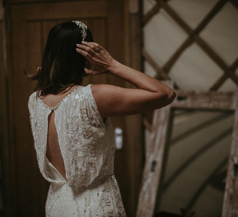 Bride looks in the mirror as she gets ready on the day of her wedding