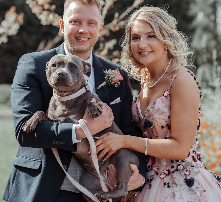 Bride & groom stand with their Staffordshire bull terrier 