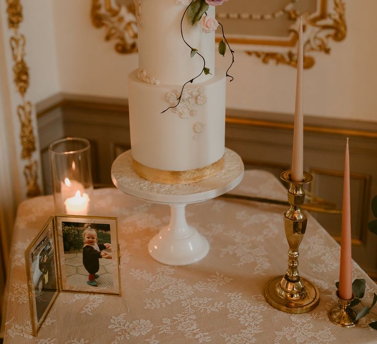 Two tier wedding cake with white frosting and pink floral decor 