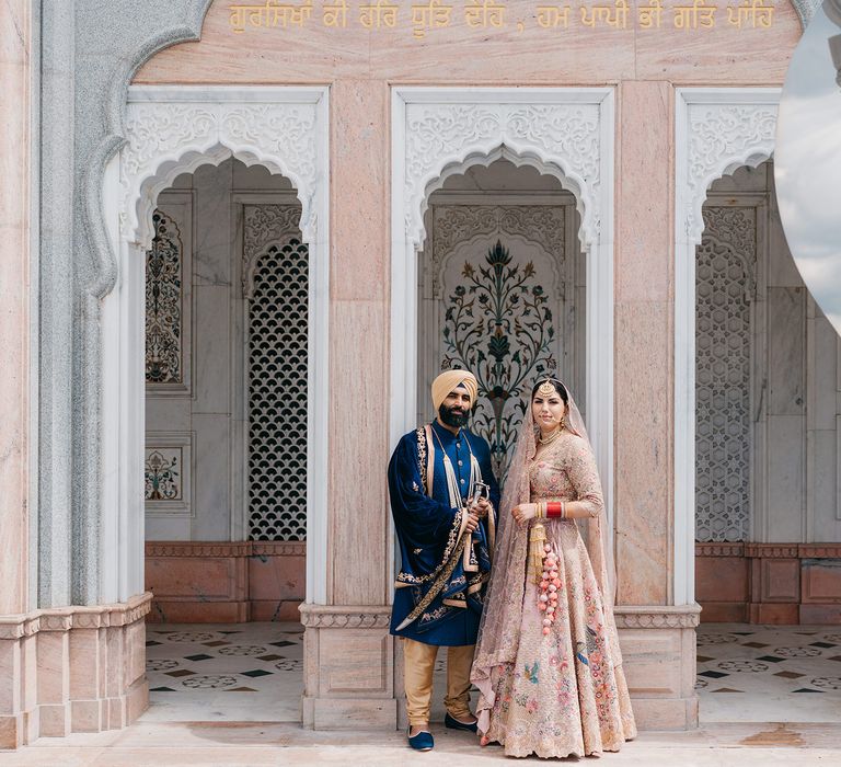 Bride & groom stand between archways after wedding ceremony