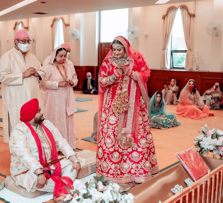 Groom sees bride for the first time during wedding ceremony as he looks up lovingly at her