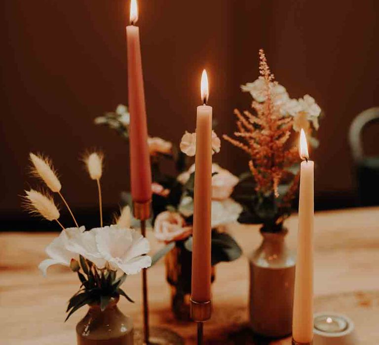 Blush tone floral decor with candles in gold candlesticks