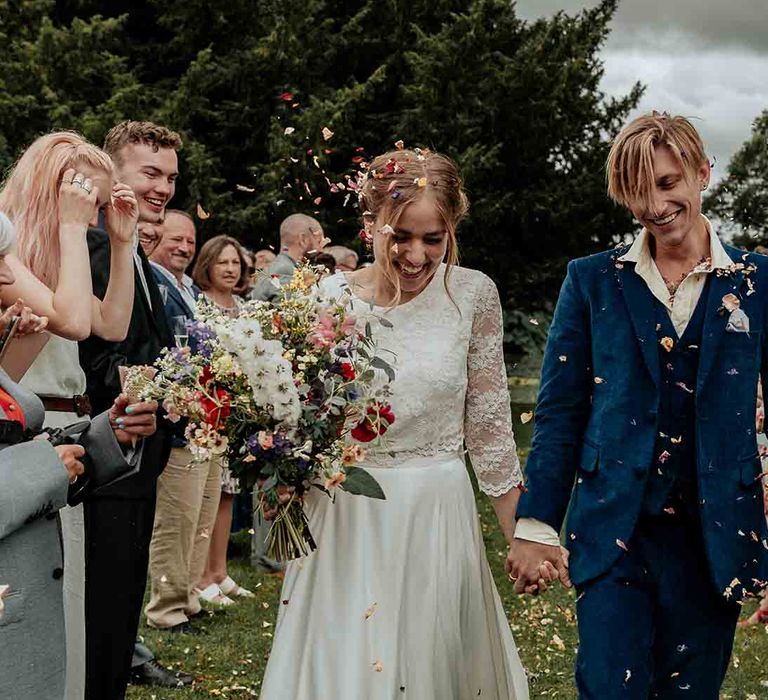 Confetti moment for bride and groom at outdoor wedding at Cadhay House