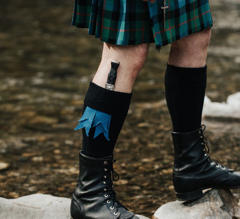 Groom in a blue and green kilt with knee high socks, boots and knife 