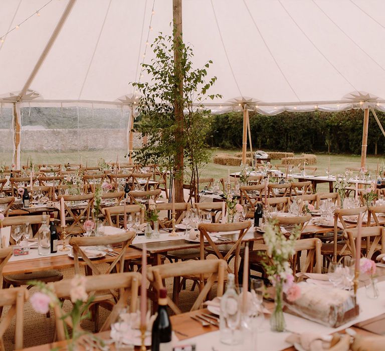 Rustic wooden tables in marquee wedding venue