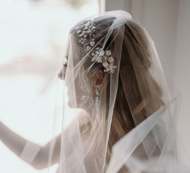 Bride looks out the window on her wedding day