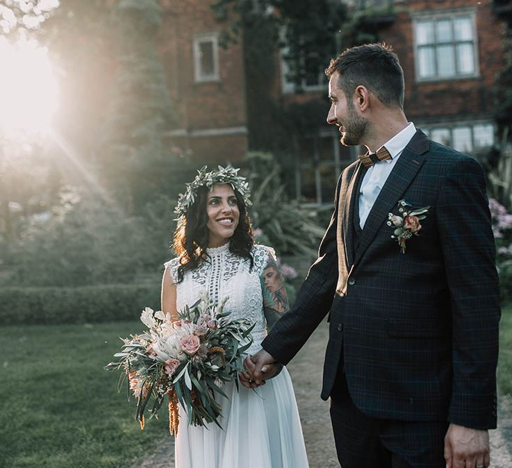 Bride & groom walk hand in hand after their wedding ceremony outdoors 