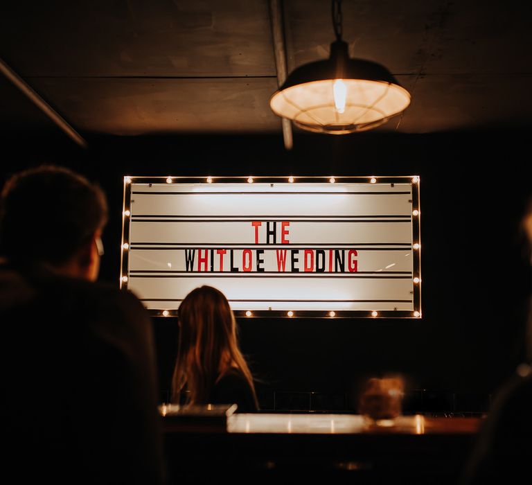 Wedding cinema style sign with red and black letters and bulb lights reading 'The Whiteloe Wedding'