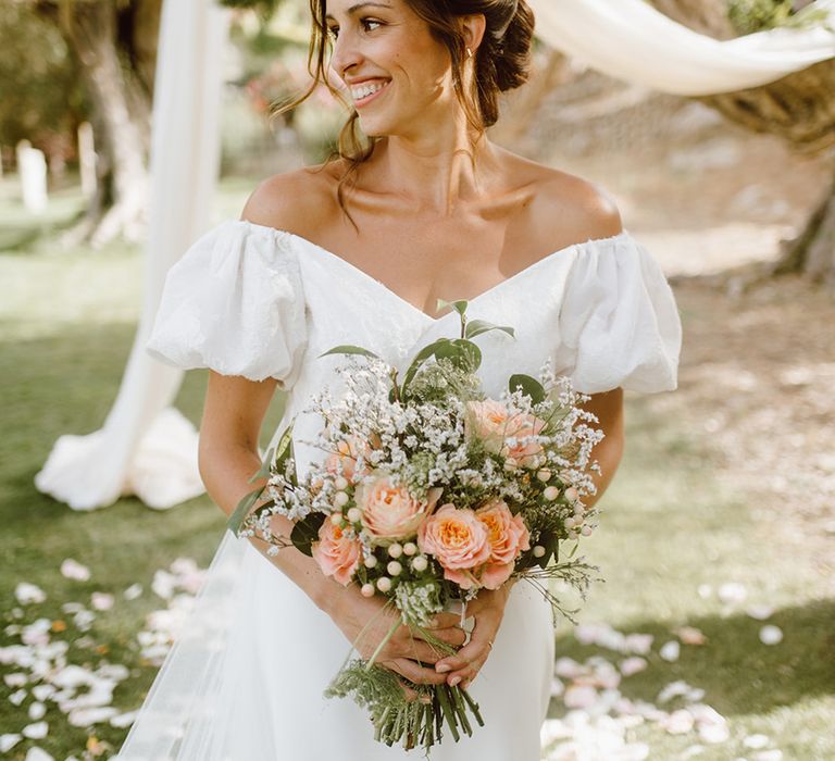 smiling bride holding pink and white bouquet 