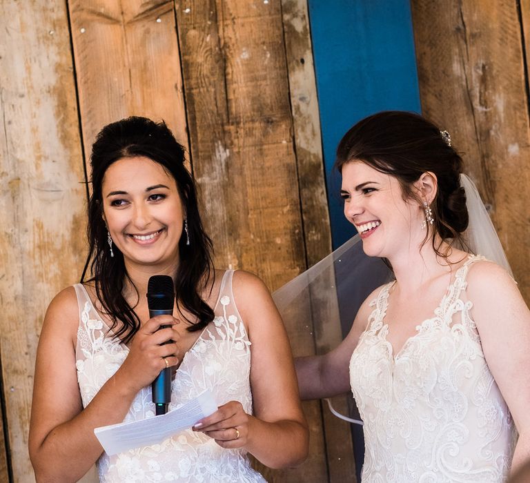 Brides stand up together as they do a bridal speech for their wedding