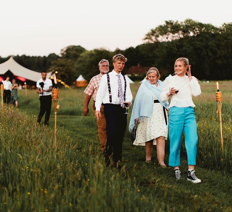 Wedding guests walk from wedding reception at home outdoor summer wedding