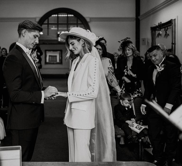 Groom puts ring on the bride during their wedding ceremony at town hall wedding 