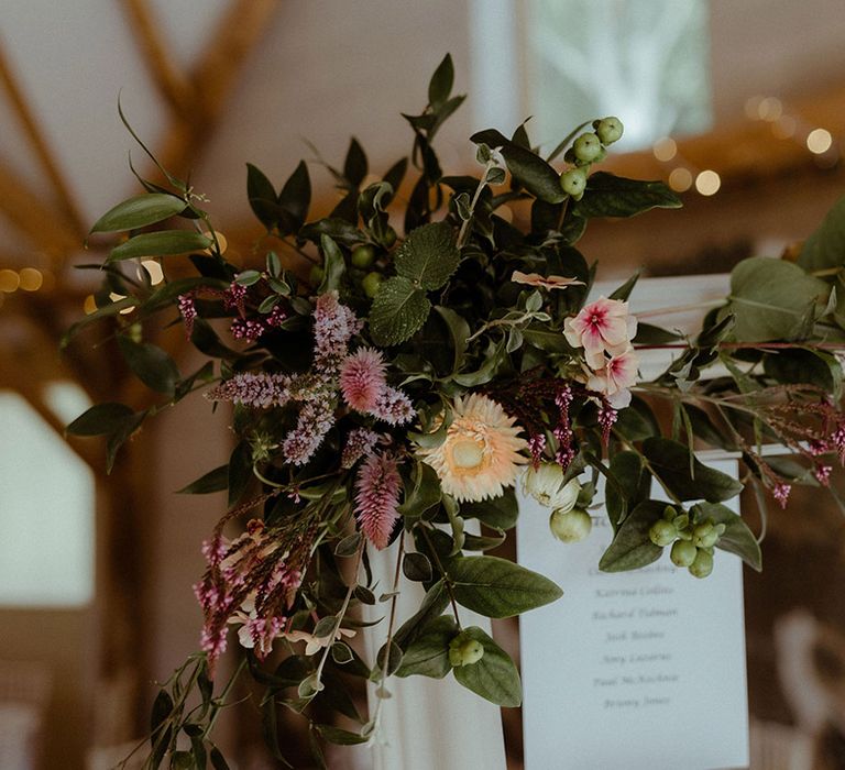 Colourful flowers and foliage decorate the wedding table plan 