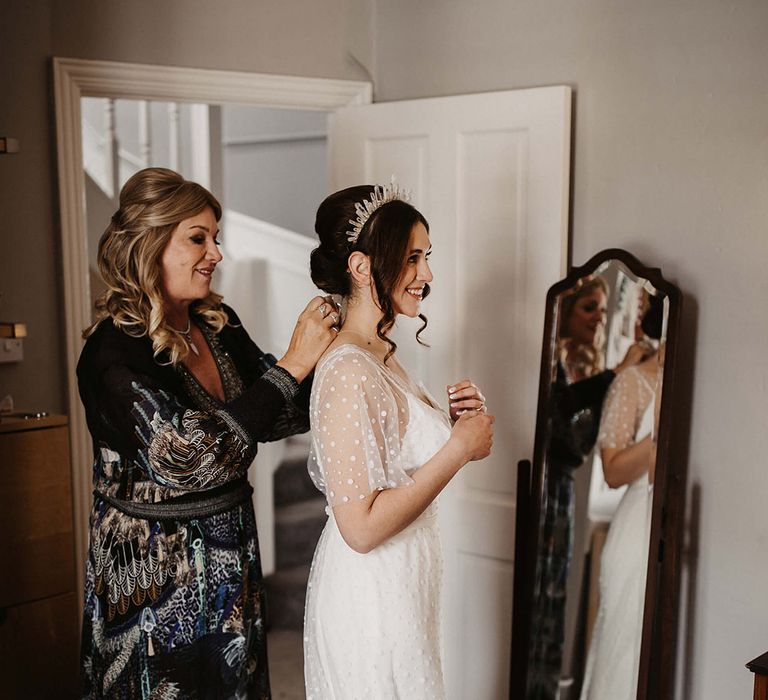 Bride in a spotted wedding dress gets ready for her big day with a crystal bridal crown 