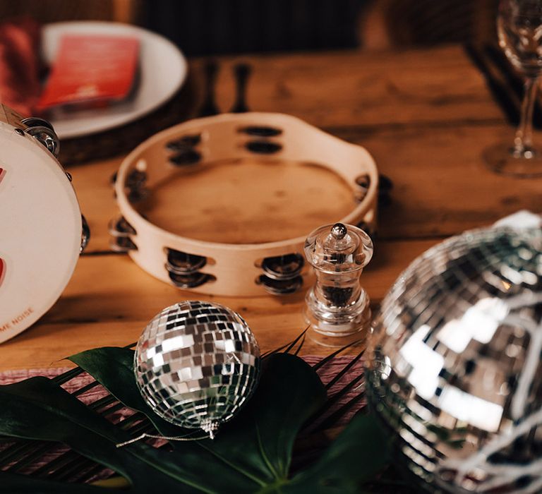 Custom red retro font tambourine table names with disco balls and tambourines for the guests