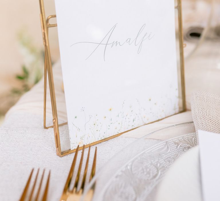 Gold arched photo frame with the table name for the Italian inspired wedding day 