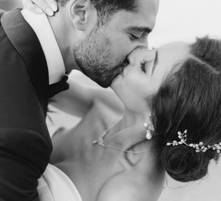 Groom dips his bride for a kiss in black & white image for couples portraits 