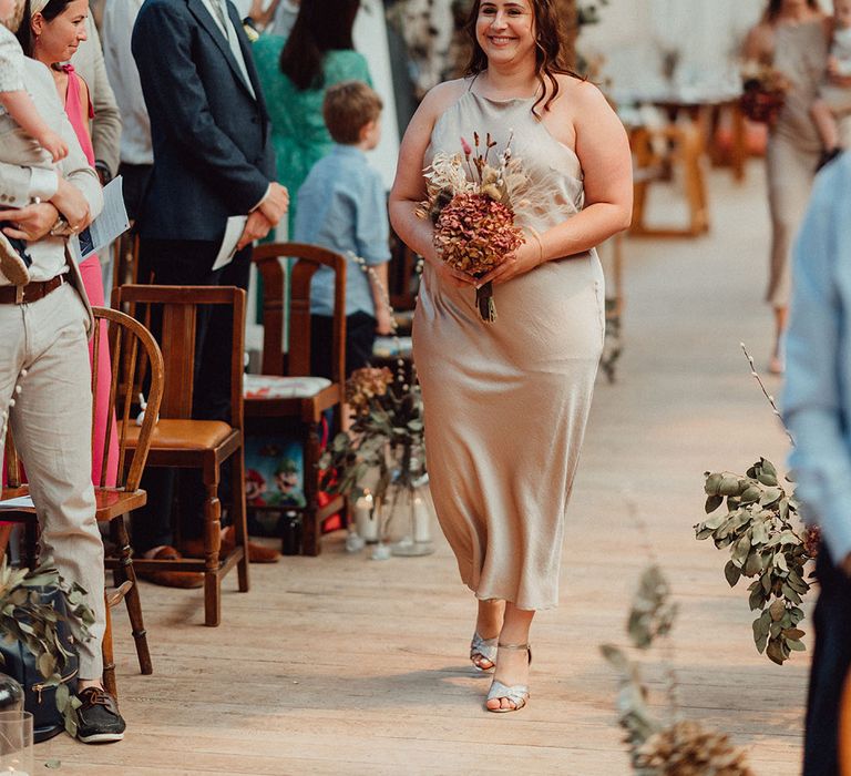 Bridesmaid in satin champagne gold bridesmaid dress with dried flower bouquet made with hydrangea and dried grass