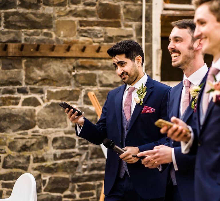 Groomsmen wear three piece suits complete with pink ties and floral buttonholes 