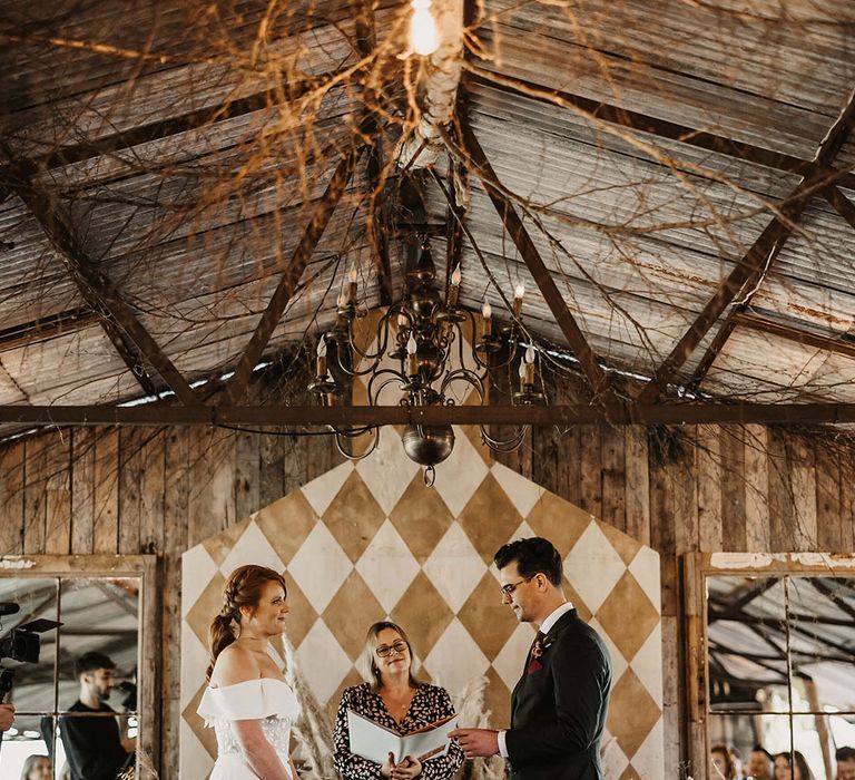 Bride & groom marry during bespoke ceremony at The Dreys wedding venue surrounded by Autumnal dried floral arrangements