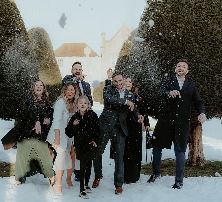 Intimate micro wedding at Stroud Registry Office in the Cotswolds with the wedding party playing in the snow 