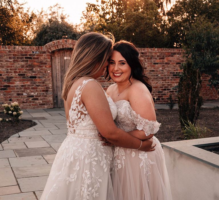 Romantic same sex wedding at The Oakwood at Ryther with the two brides sharing an embrace in lace wedding gowns 