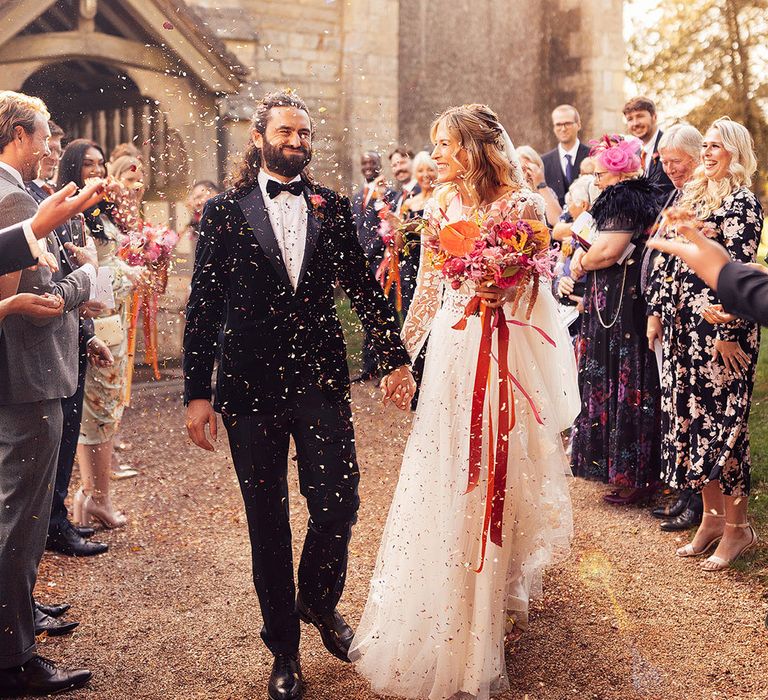 Bride and groom exit their church wedding to confetti 