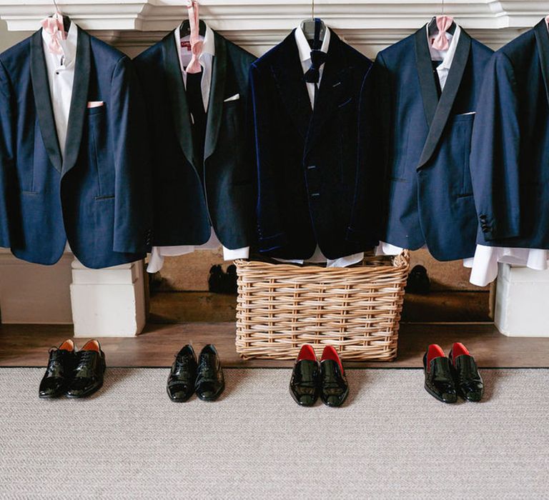 The groom and groomsmen's tuxedo jackets and shoes lined up for them 