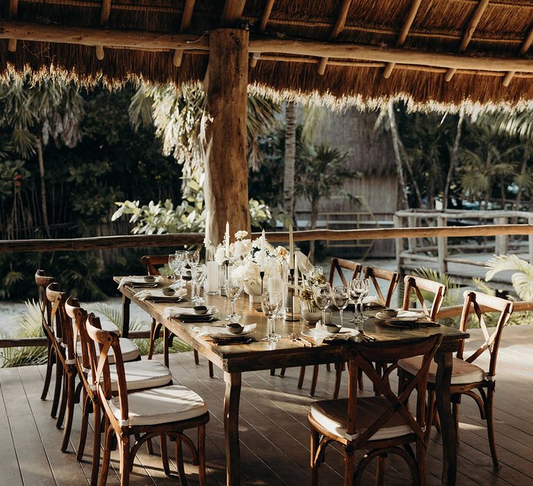 blue venado beach wedding reception in a palapa hut with white wedding flowers 