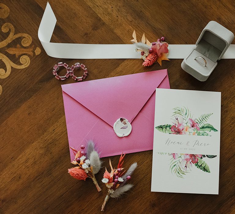 wedding invitation with with tropical flower design and pink envelope