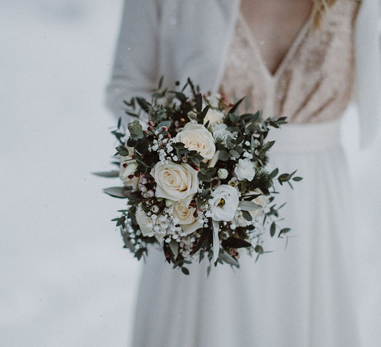 Small round bouquet of white flowers including roses and gypsophila 