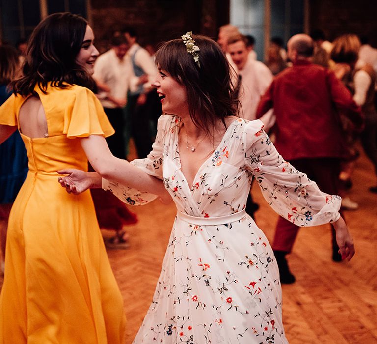 Bride in floral embroidered Sassi Holford wedding dress at wedding reception 