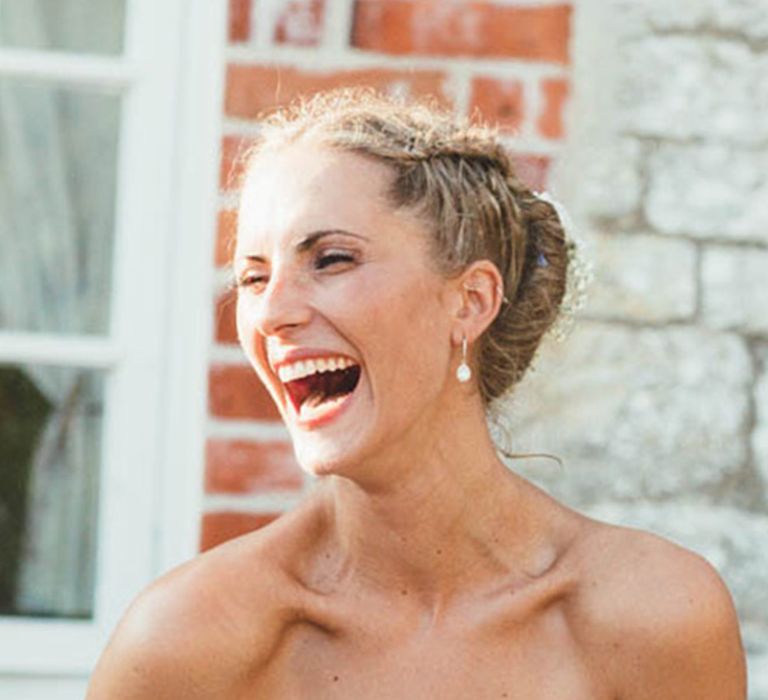 Bride in strapless wedding dress holding champagne glass with red nails 